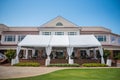 White event tent captured outside country club building before an outdoor wedding ceremony