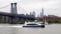 White excursion motor boat underway on the East River, Williamsburg Bridge, New York, NY, USA Royalty Free Stock Photo