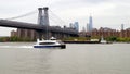 White excursion motor boat underway on the East River, Williamsburg Bridge, New York, NY, USA Royalty Free Stock Photo
