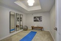 White exercise room with a bench, mirror and workout accessories