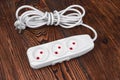 White extension. Electrical power white strip or extension block with sockets on wood background. Strip. Close up