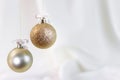White fabric background with golden Christmas spheres.