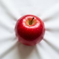 The white fabric beneath the apple has subtle folds adding depth to the Royalty Free Stock Photo