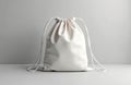 White fabric drawstring bag rests on clean surface. Simple casual sack offers versatile carry solution. Lightweight gym pack Royalty Free Stock Photo
