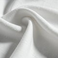 White fabric with a gently twisting drape creates soft folds and shadows. The materia Royalty Free Stock Photo