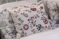 White fabric pillows with beautiful embroidered flower patterns on the bed interior