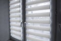 White fabric roller blinds on the white plastic window in the living room. Roll curtains indoor. Royalty Free Stock Photo