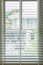 White fabric roller blinds on the plastic window with wood texture. Window with open modern horizontal white blinds indoor. White Royalty Free Stock Photo