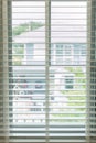 White fabric roller blinds on the plastic window with wood texture. Window with open modern horizontal white blinds indoor. White Royalty Free Stock Photo