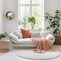 White fabric sofa with peach color blanket between green houseplant. Round knitted rug against of window. Nordic interior design