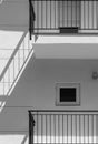 White facade of a flat building with minimalist design and small windows. The shadow of the black railing is projected on the wall Royalty Free Stock Photo