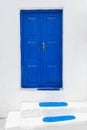 White facade of the house and blue door with stairs. Santorini island, Greece Royalty Free Stock Photo