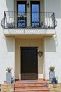 White facade of a private house with an open black wrought iron balcony Royalty Free Stock Photo