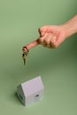 White family paper house. House keys in hand on mint background paper. Minimalistic and simple concept, style. Copy space. Royalty Free Stock Photo