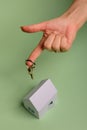 White family paper house. House keys in hand on mint background paper. Minimalistic and simple concept, style. Copy space. Royalty Free Stock Photo