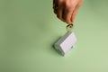 White family paper house. House keys in hand on mint background paper. Minimalistic and simple concept, style. Copy space. Royalty Free Stock Photo