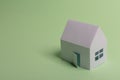 White family paper house in man hand on mint background paper. Minimalistic and simple concept, style. Copy space. Horizontal Royalty Free Stock Photo