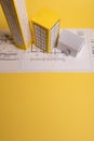 White family paper house over block of flats on yellow background paper. Minimalistic and simple concept, style. Copy space. Royalty Free Stock Photo