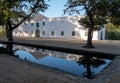 Cape Dutch style farm building at Groot Constantia, Cape Town, South Africa, reflected in a pond in the early morning. Royalty Free Stock Photo