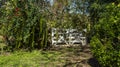 White farm gate, with many plants in the background. Royalty Free Stock Photo