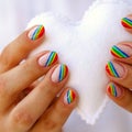 White felted heart in femaile hands with rainbow manicure. Love, valentine, lgbt, pride concept Royalty Free Stock Photo