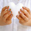 White felted heart in femaile hands with rainbow manicure. Love, valentine, lgbt, pride concept Royalty Free Stock Photo