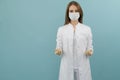 White female doctor in a mask and coat on a blue background