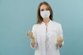 White female doctor in a mask and coat on a blue background