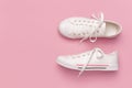 White female fashion sneakers on pink background. Flat lay, top view, copy space. Women`s shoes. Stylish white sneakers. Fashion