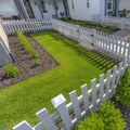 White fence around a sunlit landscaped yard