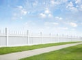 White fence, grass, sidewalk, blue sky and clouds Royalty Free Stock Photo