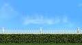 White fence and hedge on blue sky