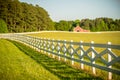 White fence leading up to a big red barn Royalty Free Stock Photo