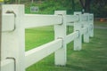 White fence at outdoor garden with green grass and tree background. Royalty Free Stock Photo