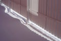 White fence in winter. Snow lies under the fence. The sun breaks through under the fence, falling on the bright white snow. Royalty Free Stock Photo