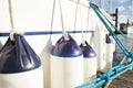 White fenders suspended between a boat and dockside Royalty Free Stock Photo