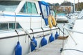 White fenders suspended between a boat and dockside for protection. Maritime fenders Royalty Free Stock Photo