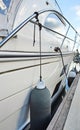 White fenders suspended between a boat and dockside for protection. Maritime fenders Royalty Free Stock Photo