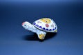 White feng-shui turtle colored metal with detachable carapace shell for jewelry depositing on dark background Royalty Free Stock Photo