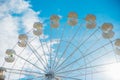 White Ferris wheel cabins on a blue sky background. A public amusement park. Abstract background