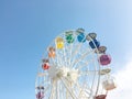 White ferris wheel with colorful cabs on a background of blue sky. Royalty Free Stock Photo