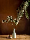 White fieldflowers branch inside glass vase