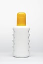 White figured plastic bottle with a yellow cap on a white background