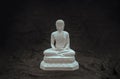 White figurine of siddhartha gautama buddha sculpture statue with dark background Royalty Free Stock Photo