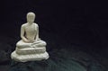 White figurine of siddhartha gautama buddha sculpture statue with dark background Royalty Free Stock Photo