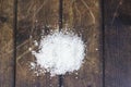 White fine coarse sugar spilled on wooden table
