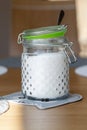 White fine sugar in retro large glass jar on table