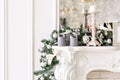 White fireplace decorated with candles and fir branches. Decorated Christmas tree. Classic apartments, morning in hotel Royalty Free Stock Photo