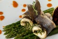 Rolls of white baked fish with asparagus sauce