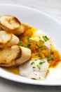 white fish with tomato sauce and roasted baguette slices Royalty Free Stock Photo